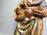 une statue ancienne d'une femme tenant un bébé dans ses bras