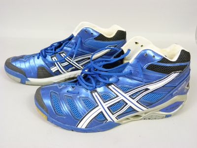 pair of blue and white tennis shoes on a white surface