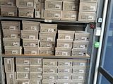 many boxes of mail sitting on a shelf next to a window