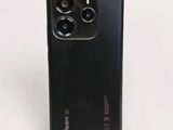 a close up of the back of a black phone on a white surface
