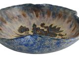 a blue and white bowl with a flower design on it