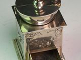 a silver coffee grinder sitting on a white surface