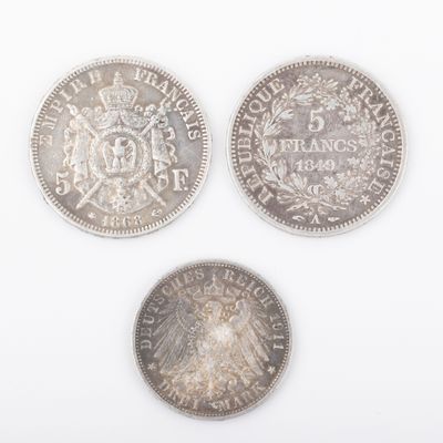 three different types of silver coins on a white surface