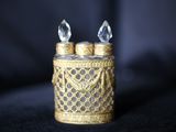 un bougeoir en or surmonté de deux bougies en cristal