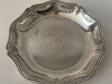 a silver plate on a table with a white background