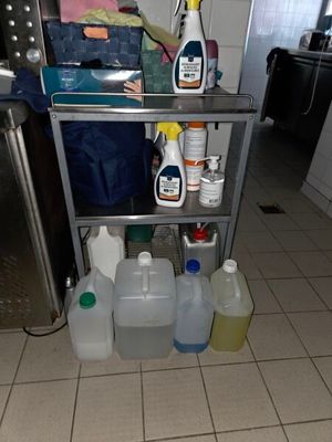 une étagère métallique sur laquelle sont posés des produits d'entretien, dans une cuisine