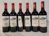 six bottles of wine are lined up on a table