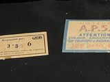 two old tickets sitting on top of a black table next to a pair of scissors