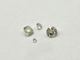 un gros plan sur trois diamants posés sur une surface blanche