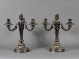 pair of silver plated candelabs with candles on stands