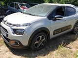 une petite voiture blanche garée dans un champ herbeux