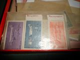 une boîte rouge sur laquelle sont représentés des timbres et un stylo