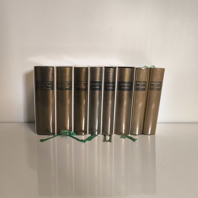 six livres sont alignés sur une surface blanche