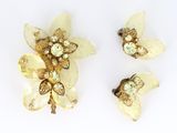 deux broches en forme de fleur de couleur dorée et une paire de boucles d'oreilles