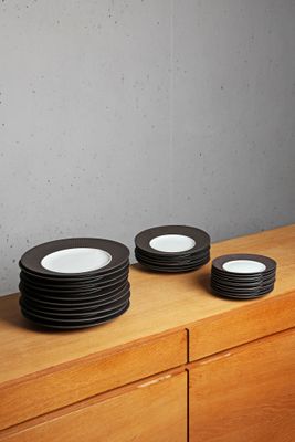 four plates sitting on top of a wooden dresser
