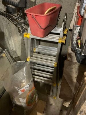un seau rouge posé sur une échelle dans un garage