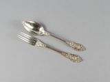 deux cuillères et une fourchette en argent sur une table