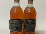 two bottles of alcohol sitting next to each other on a table