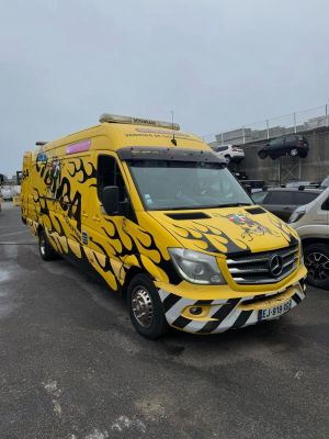 yellow van with flames painted on it parked in a parking lot