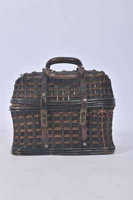 un petit panier en osier muni d'une anse, posé sur une surface blanche