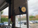 des voitures garées sur un parking à côté d'un immeuble doté d'une grande baie vitrée