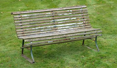 un banc en bois posé au milieu d'un champ herbeux