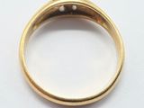a close up of a gold ring with diamonds on a white surface