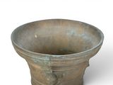 a large bronze vase sitting on top of a white surface