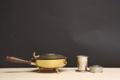 un pot jaune et une tasse en argent posés sur une table