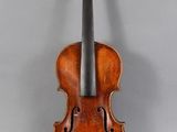 an old violin sitting on top of a table next to a wall