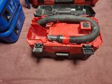 une boîte à outils rouge contenant un souffleur et une mallette bleue