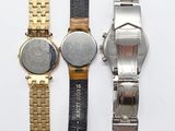 three different watches sitting on top of a table next to each other
