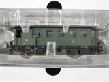 un train vert dans une boîte transparente posée sur une surface blanche