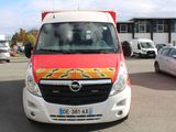 une camionnette rouge et blanche garée sur un parking