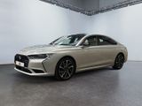 a silver car is parked in a large room with a white wall