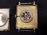 a small silver box with a watch inside of it