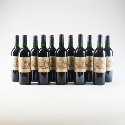 six bouteilles de vin sont alignées sur une surface blanche