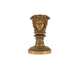 une statue en or représentant une tête coiffée d'une couronne