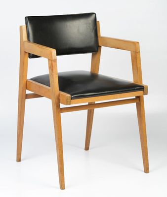 a wooden chair with a black leather seat on a white background