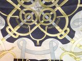 a black and gold scarf with a design on it