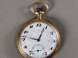 une montre de poche en or avec un cadran blanc et des chiffres