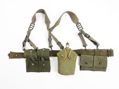three military pouchs are hanging on a wall with straps