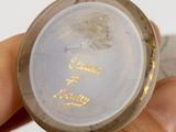 a person holding a small glass object with a gold writing on it
