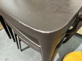 a gray table with four chairs on it in a room