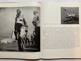 an open book with a black and white photo of a man standing next to an airplane