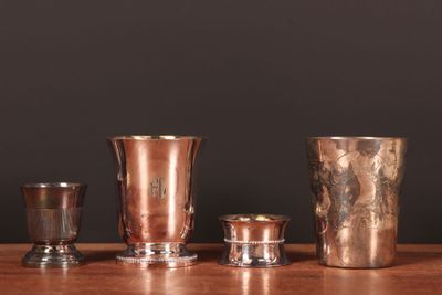 quatre types différents de vases en argent posés sur une table en bois
