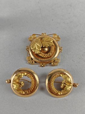 two gold tone brooches and a pair of earrings