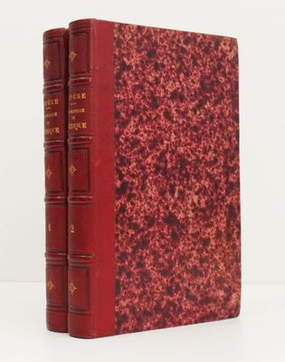 un vieux livre à la couverture rouge posé sur une table blanche