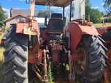 a red tractor that is parked in the grass