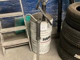 a stack of tires and a ladder next to a blue wall